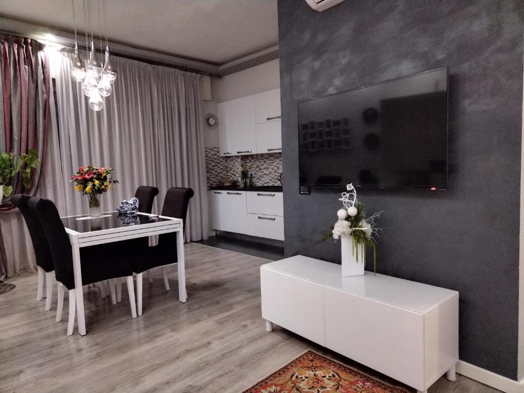 a living room with a white table and a kitchen at Appartamento Maggi in Brescia