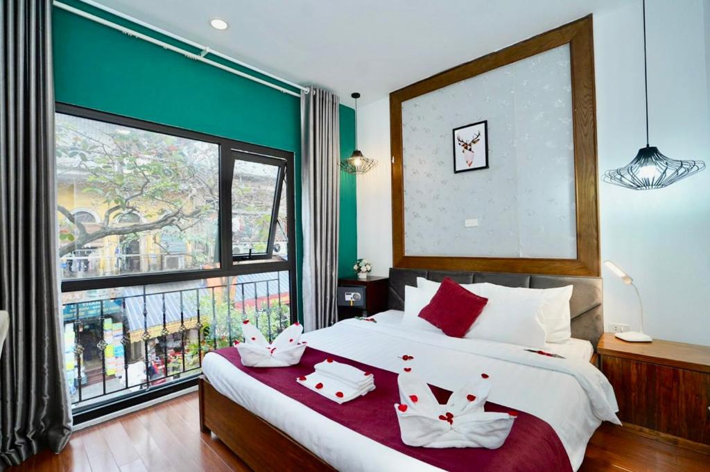 ein Schlafzimmer mit einem großen Bett und einem großen Fenster in der Unterkunft NT Elysian hotel in Hanoi