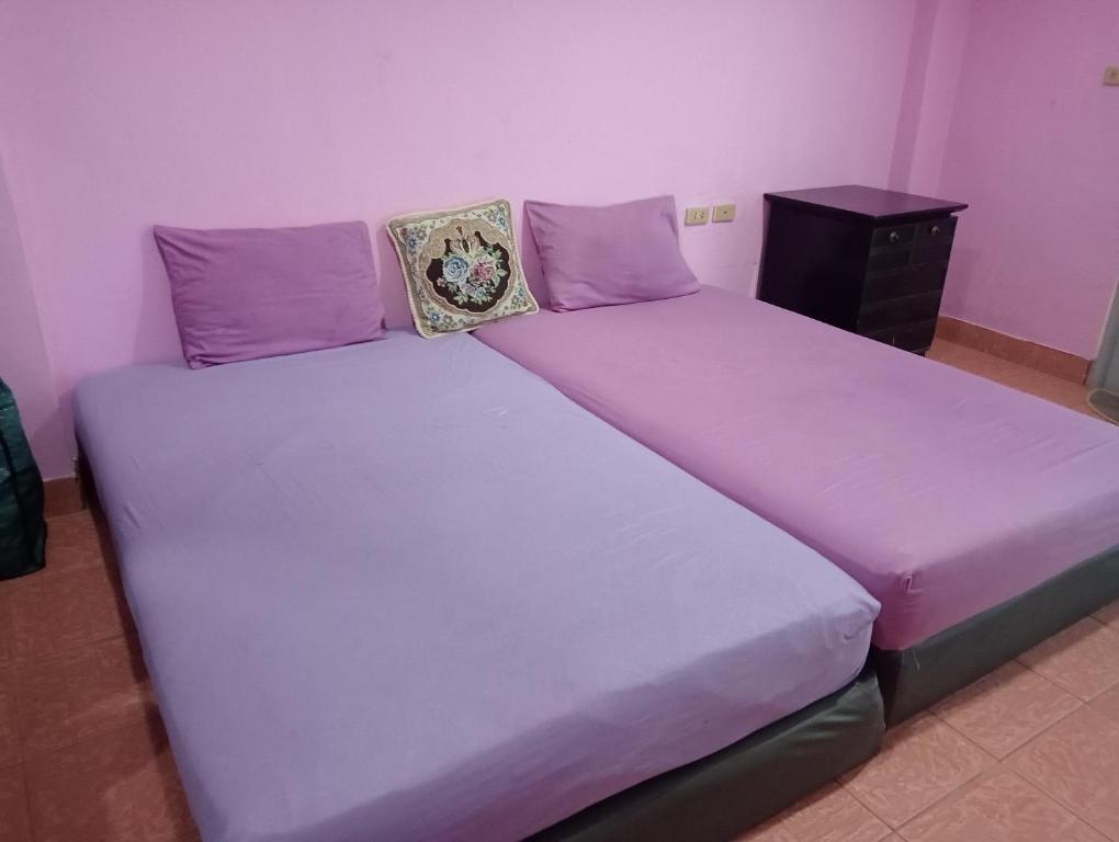 a large bed with purple sheets and pillows on it at Smile Plus by Thai Smile in Pattaya Central