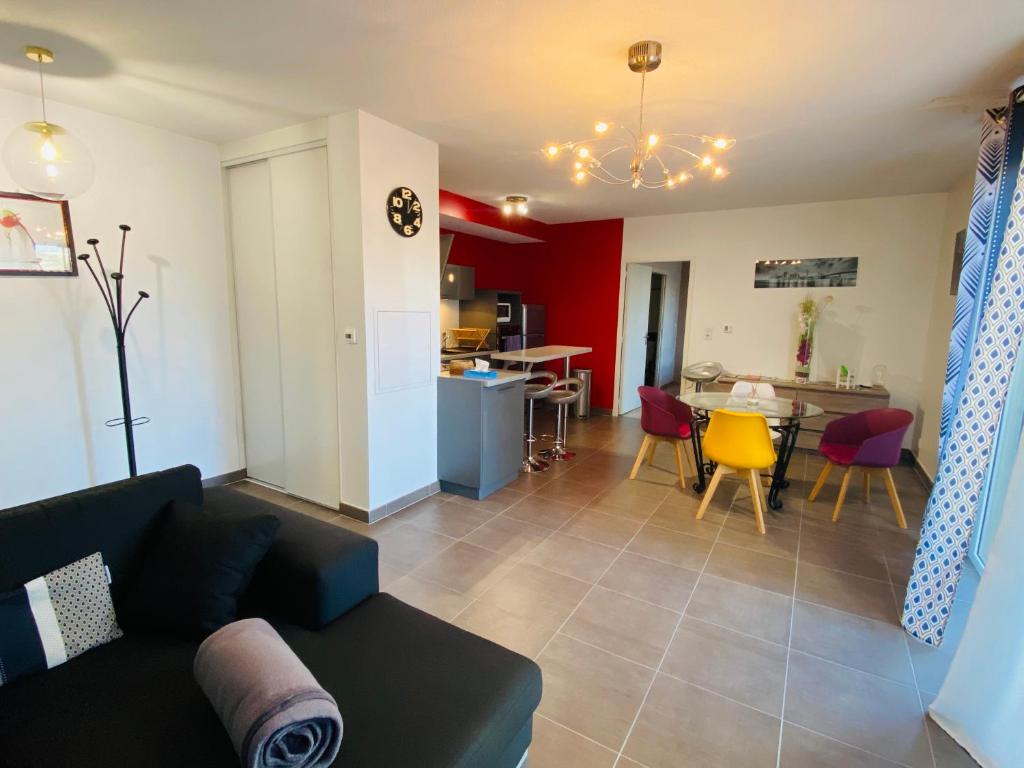 a living room and kitchen with a couch and a table at Appartement T2 cosy à Rodez in Rodez