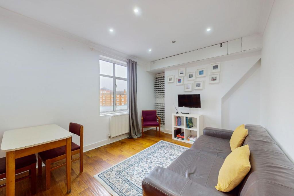 a living room with a couch and a table at Cozy 2 Bedroom Flat in Cambridge Heath in London