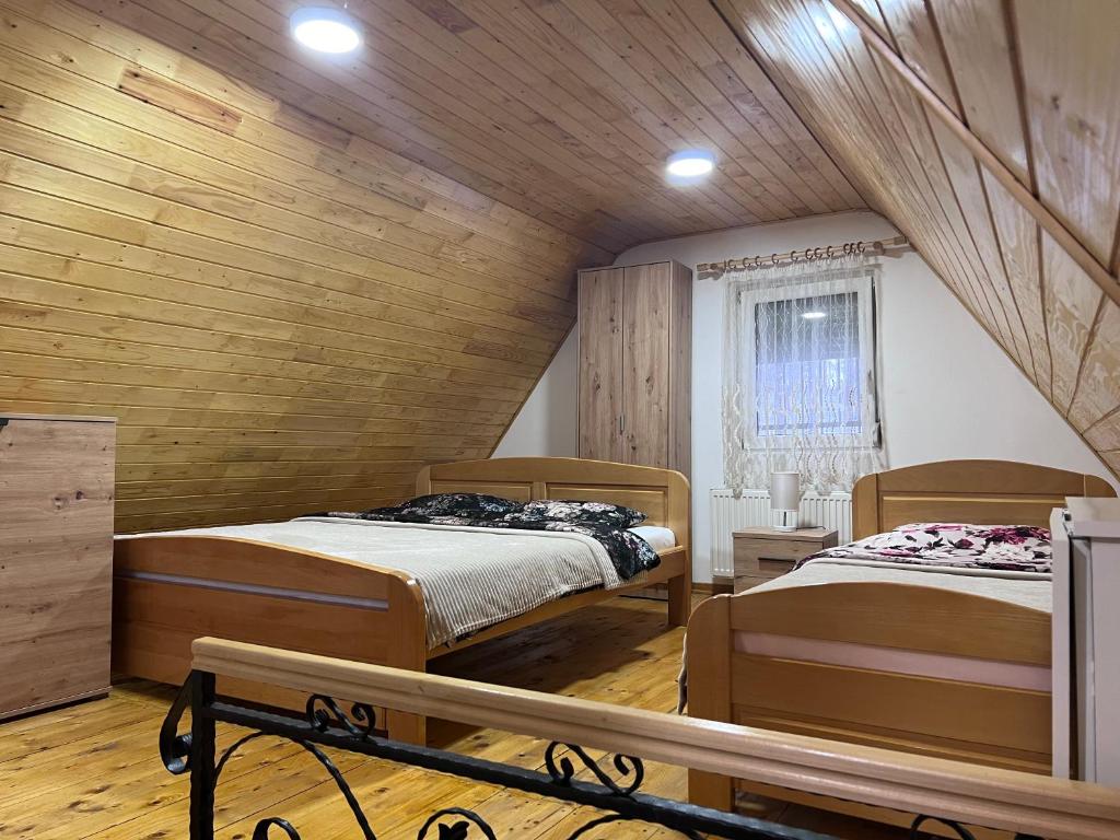 zwei Betten in einem Zimmer mit Holzwänden in der Unterkunft Vikendica Martinović in Divčibare