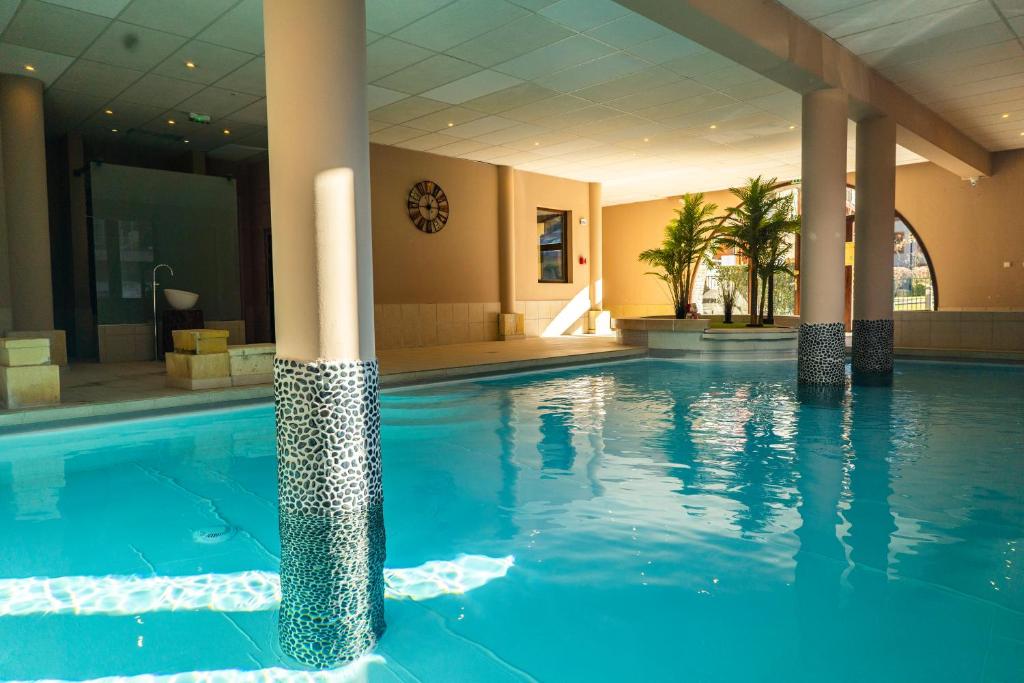 una piscina en un hotel con columnas en Résidence Cami Réal **** en Saint-Lary-Soulan