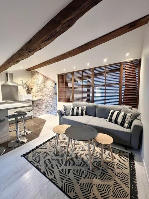 un salon avec un canapé et deux tables dans l'établissement L'Atypique - Coeur de ville, à La Rochelle