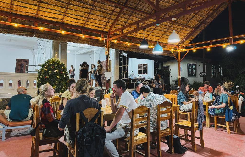 um grupo de pessoas sentadas em mesas em um restaurante em Sabai Sabai Backpackers Hostel em Luang Prabang