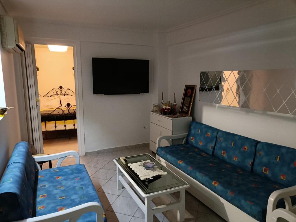 un salon avec un canapé bleu et une télévision dans l'établissement Κουκλόσπιτο, à Thessalonique