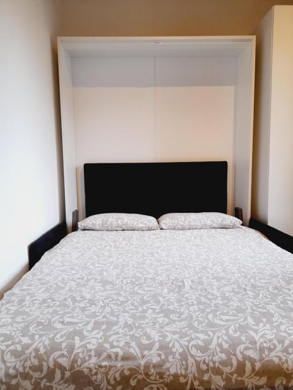 um quarto com uma cama grande e uma colcha branca em Flat in Milano, Porta Romana em Milão