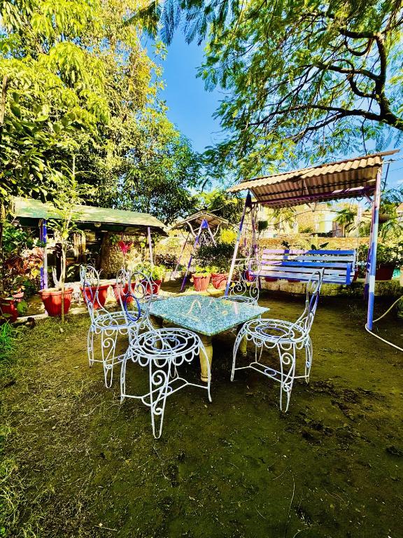 マウント・アブにあるHotel New Sun N Rock ( 1km from Nakki Lake )のブランコ付きの庭のテーブルと椅子