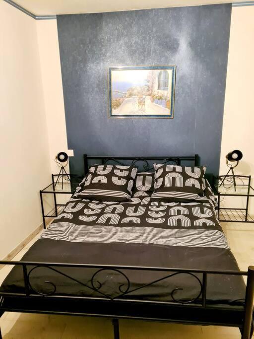 a bedroom with a black bed with a blue wall at Maison Jean Léone in Gevrey-Chambertin