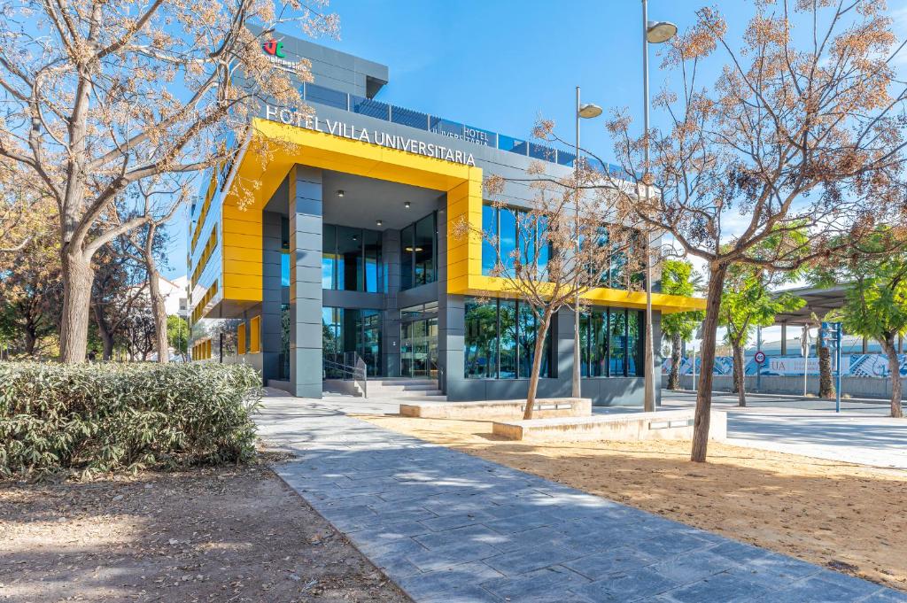 un edificio con un toldo amarillo delante de él en Hotel Villa Universitaria, en San Vicente del Raspeig