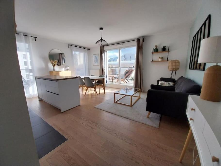 un salon avec un canapé et une table dans l'établissement Confort à Asnières, à Asnières-sur-Seine