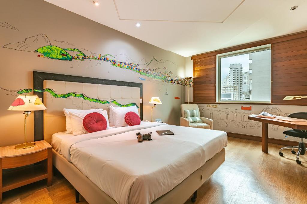 een slaapkamer met een groot bed en een bureau bij Pestana São Paulo in Sao Paulo