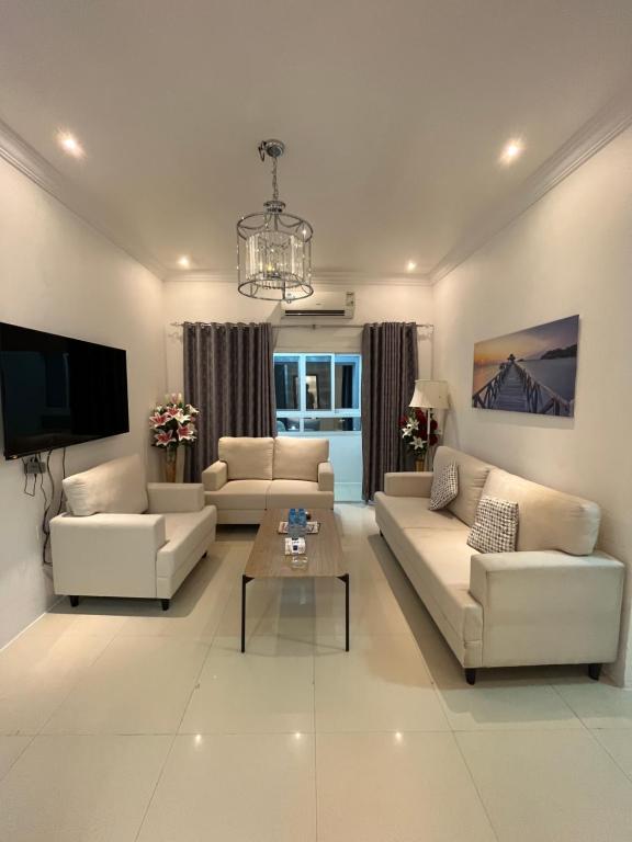 a living room with two couches and a tv at كورنيش عجمان in Ajman 