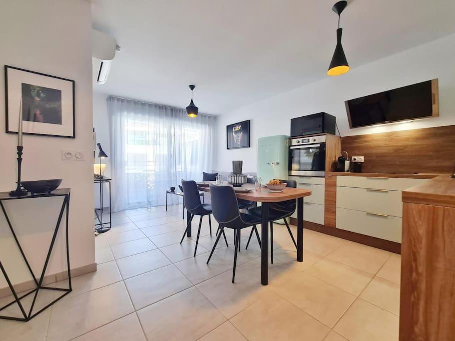 eine Küche und ein Esszimmer mit einem Tisch und Stühlen in der Unterkunft TLN-0011 - Magnifique appartement proche centre-ville in Six-Fours-les-Plages