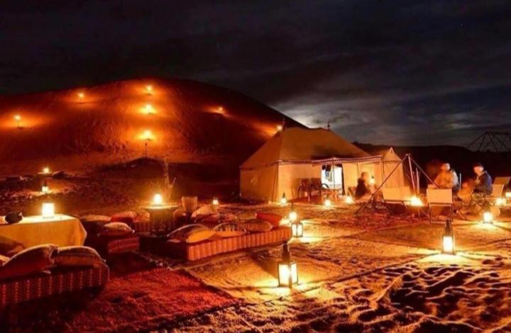 una grande tenda con luci nel deserto di notte di Desert Berber Fire-Camp a Merzouga