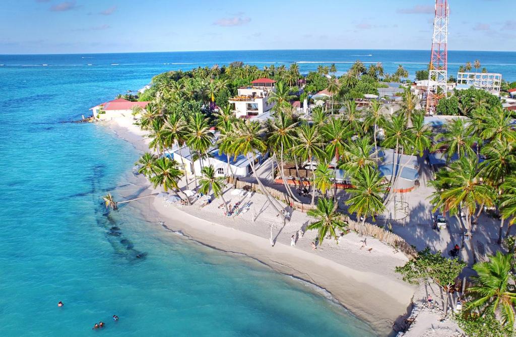 an aerial view of a beach with palm trees at Faza View Inn, Maafushi in Maafushi