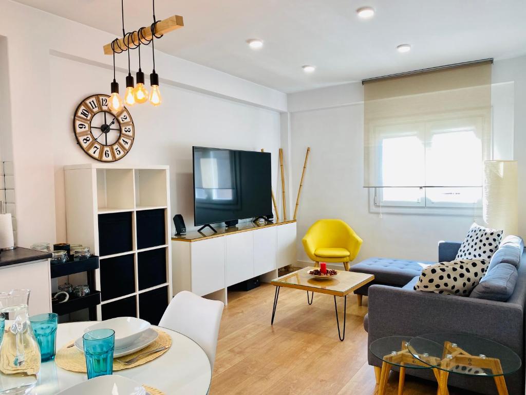 a living room with a couch and a tv at Apartamento HC13 - PUERTA PURCHENA in Almería