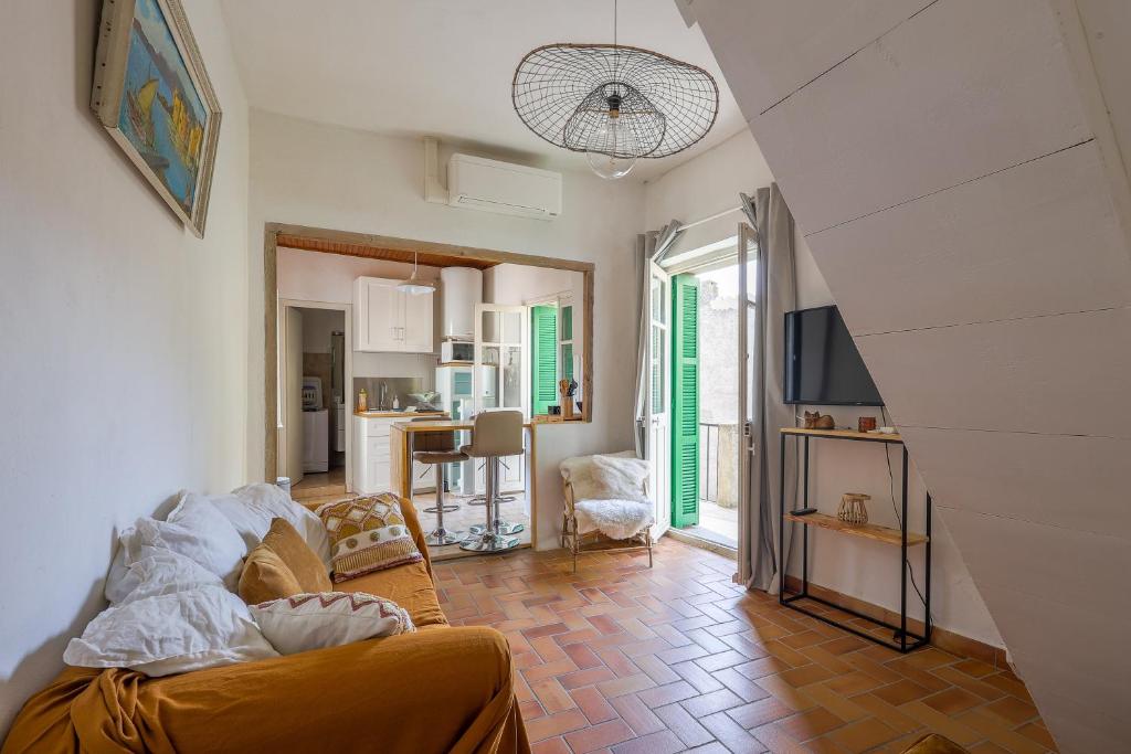 uma sala de estar com um sofá e uma televisão num quarto em Di Mezzu - Proche plage et vue montagnes em Corbara