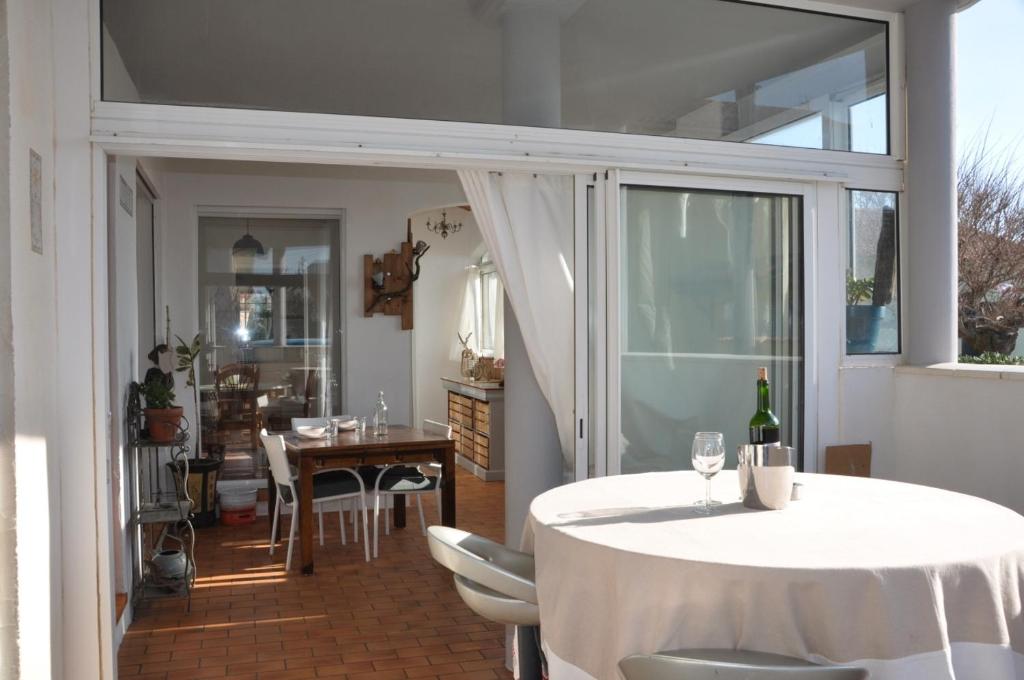 une salle à manger avec une table et des chaises blanches et une salle avec une table à manger dans l'établissement Les Nautiles, à Narbonne-Plage