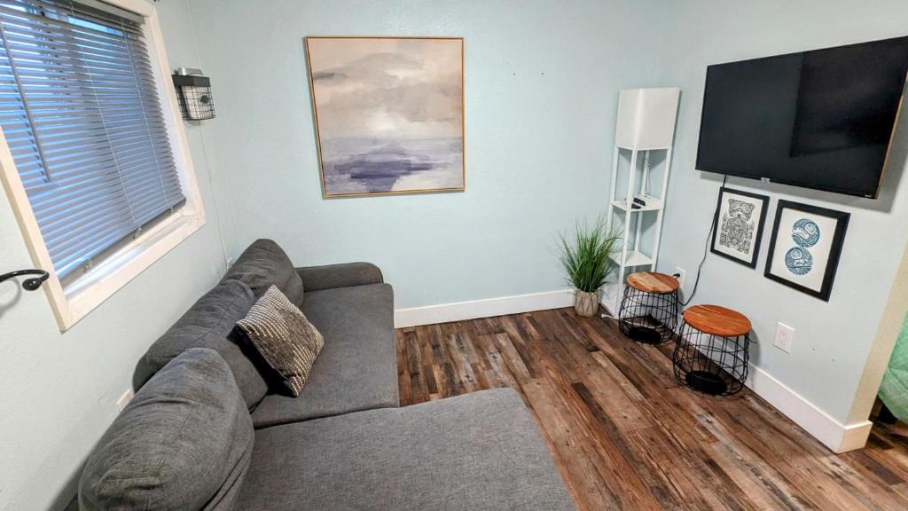 uma sala de estar com um sofá e uma televisão de ecrã plano em 1964 Earthquake Cottage - Slumber Village 10 em Anchorage