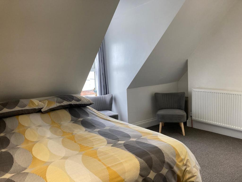 a bedroom with a bed and a chair at Ashburnam Guest House in Hornsea