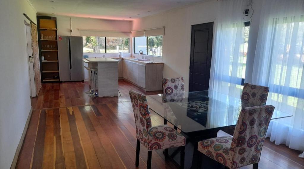 a kitchen with a glass table and two chairs at Casa de vacaciones in Dos de Mayo