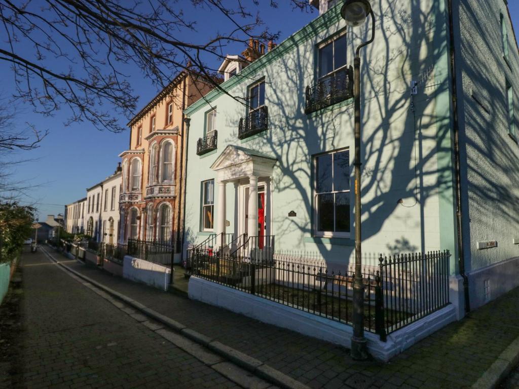 a white building with a red door on a street at 8 Corkickle in Whitehaven