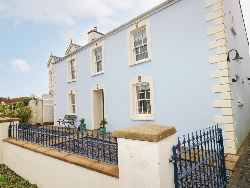 a white house with a blue fence at The Old Boathouse in Haverfordwest