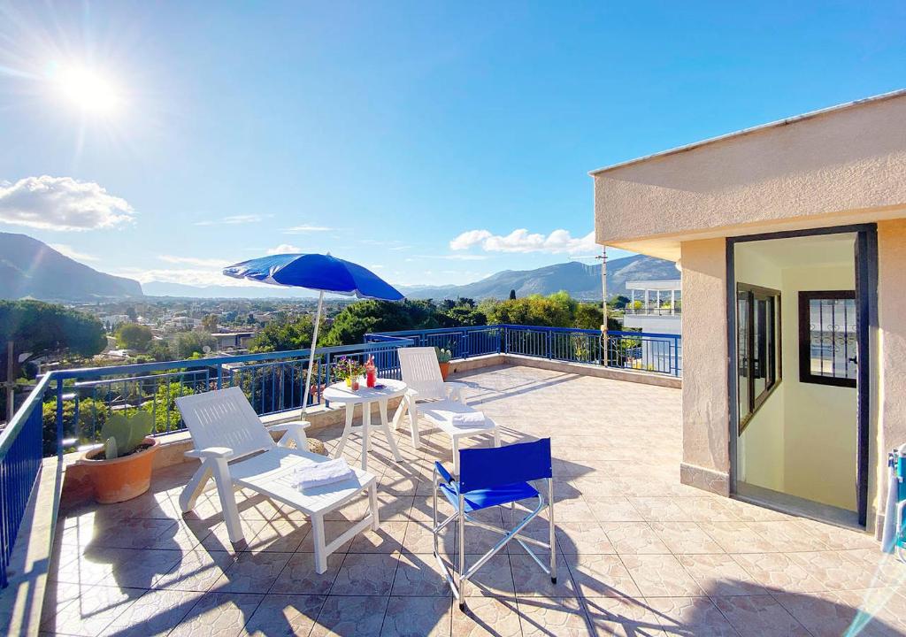 a patio with chairs and a table and an umbrella at Solemar Sicilia - Villa Mariù in Palermo