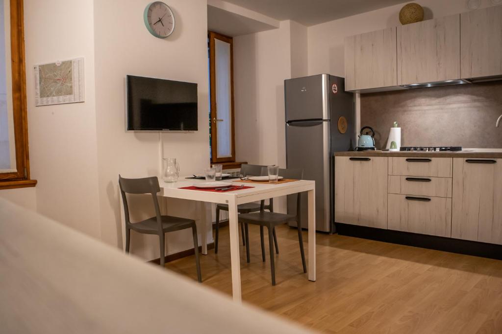 a kitchen with a table and chairs and a refrigerator at Case Vacanze Berton Tirano in Tirano