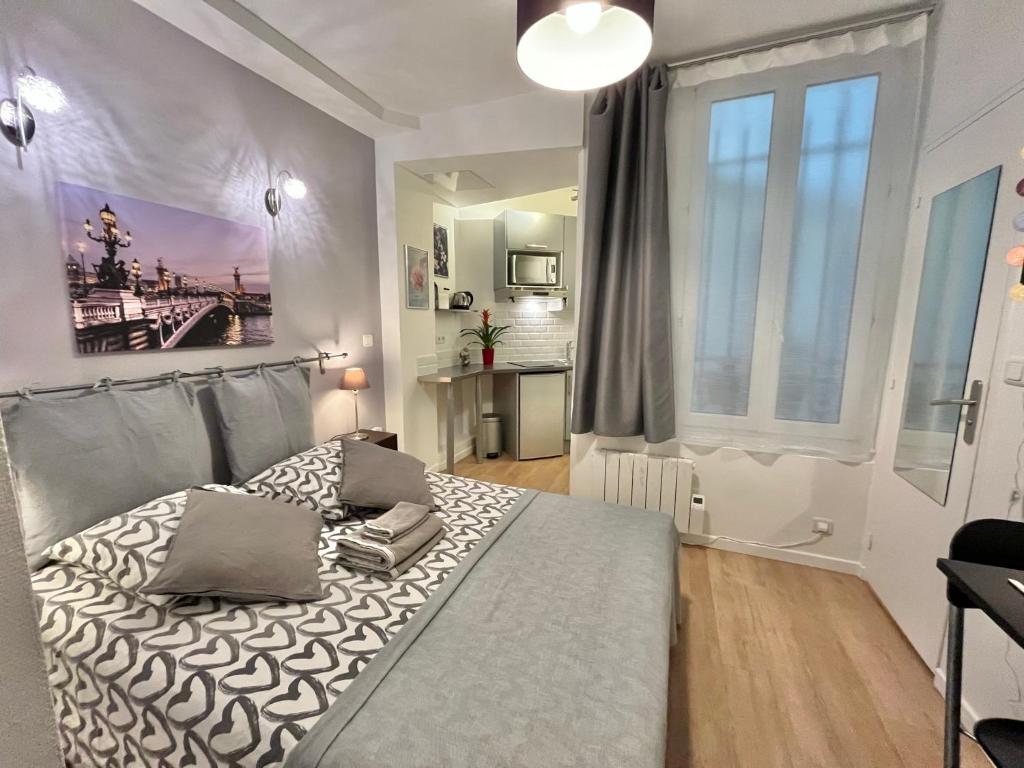 um quarto com uma cama e uma grande janela em Apartment Paris Studios em Paris