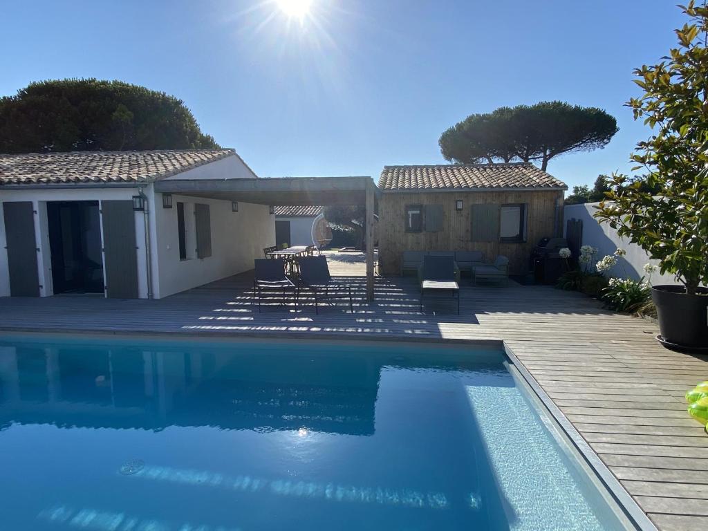 une piscine devant une maison dans l'établissement La villa Bremaudières - Villa pour 14 personnes avec Piscine à 150m de la mer, au Bois-Plage-en-Ré