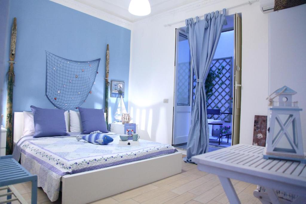 a blue bedroom with a bed and a table at Vacanze Palermitane in Palermo