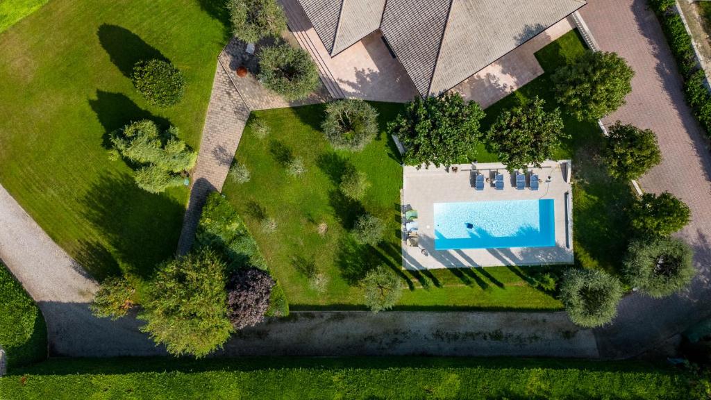 - une vue sur la cour et la piscine dans l'établissement Villa Carini with 3000 mq garden & heated pool, à Castelnuovo del Garda