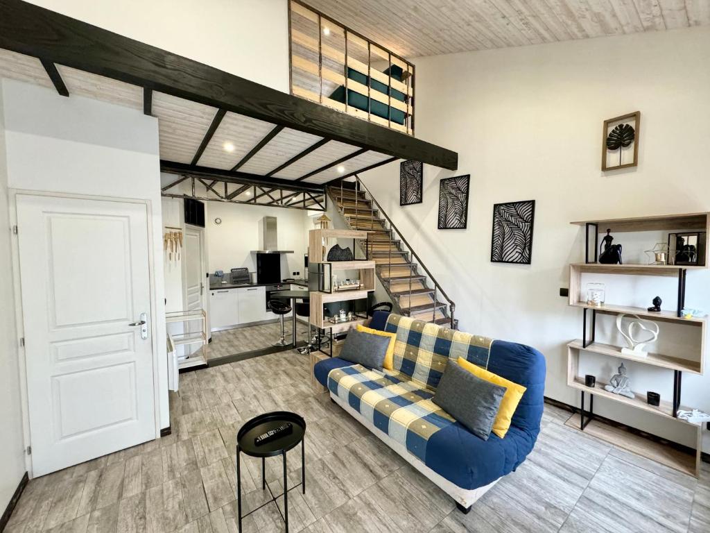 a living room with a blue couch and a staircase at Havre de paix avec jardin in Paray-le-Monial