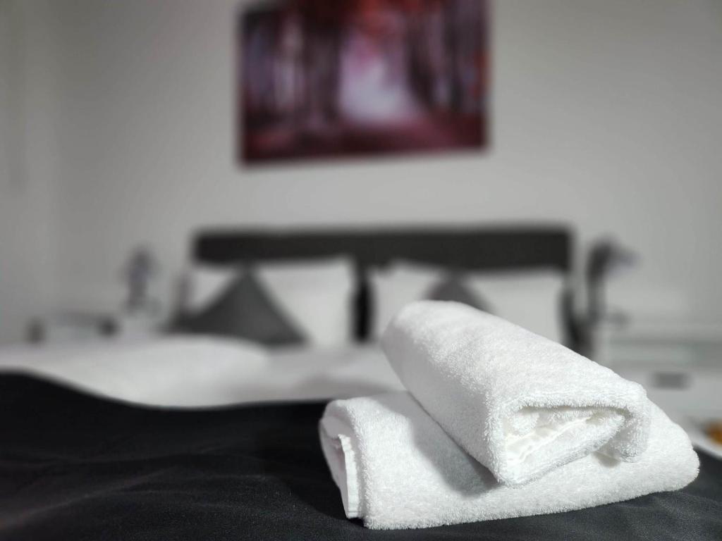 a stack of towels sitting on top of a bed at HOTEL Schiff in Rastatt