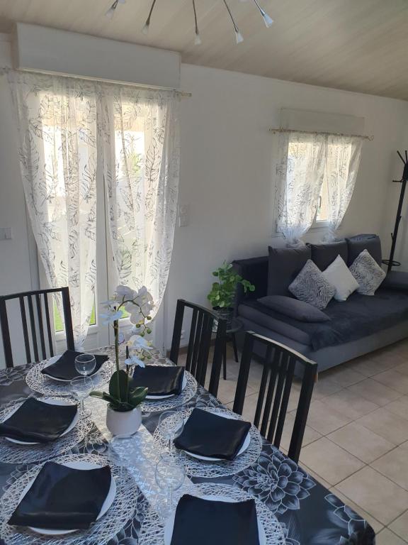 une salle à manger avec une table et un canapé dans l'établissement Maison de vacances plein pied tout confort 200m plage, à Portiragnes