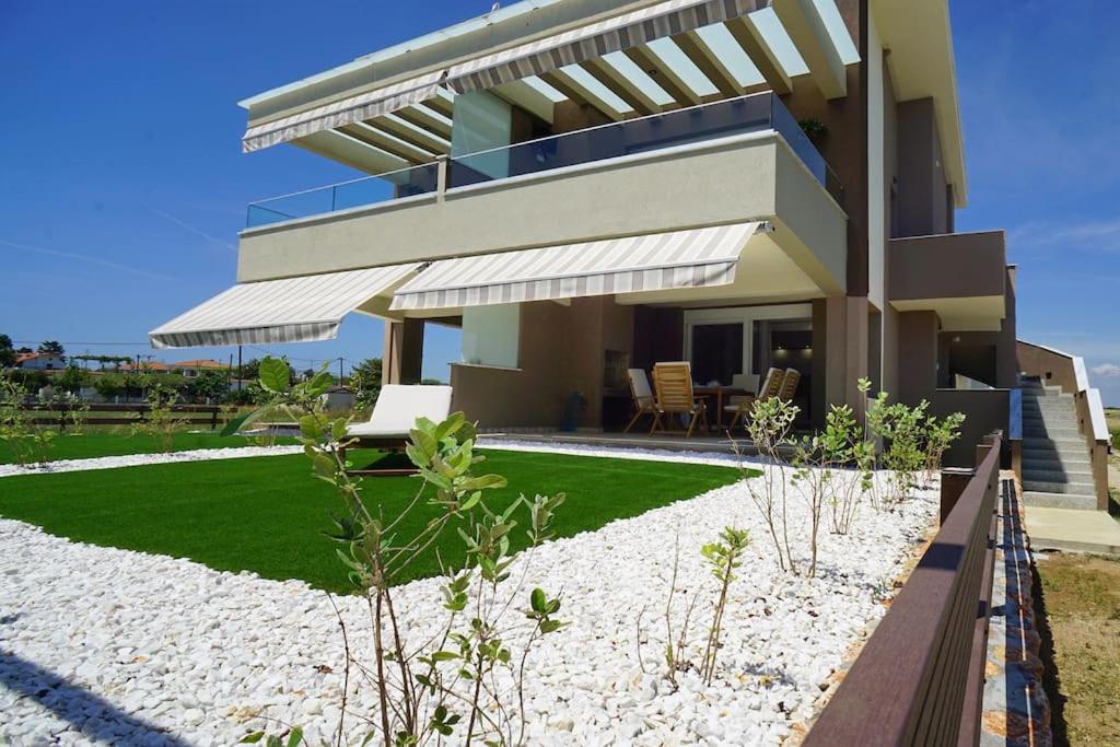 a house with a lawn in front of it at Avra Vip Villa in Paralía Avdhíron