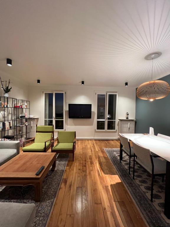 ein Wohnzimmer mit einem Tisch und grünen Stühlen in der Unterkunft 70m2 Cosy Apartment Daguerre in Paris