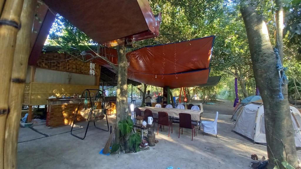 a table and chairs are set up under a tree at Secluded Glamping Yoga Samadhi Resort 
