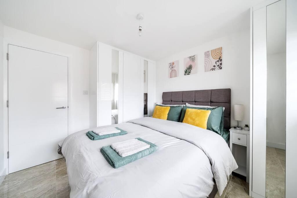 a white bedroom with a large bed with towels on it at Stylish Contemporary 1 Bed Flat Near London Bridge in London