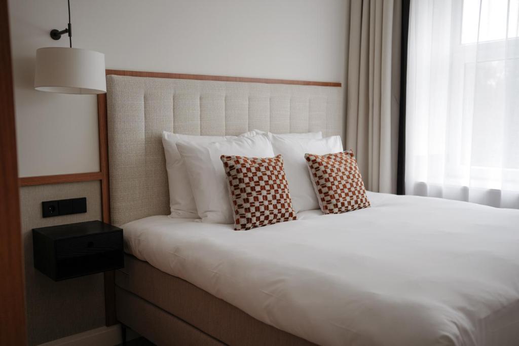 uma cama com duas almofadas num quarto em By Friso Den Haag em Scheveningen