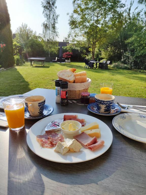 a table with a plate of breakfast food on it at Maison Egalité in Melay