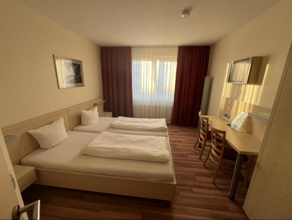 ザルツバーゲンにあるAutohof Hotel Salzbergenのベッド2台とデスクが備わるホテルルームです。
