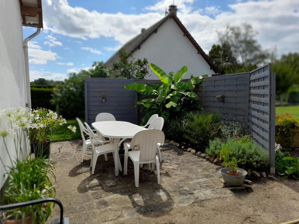 une table et des chaises devant une clôture dans l'établissement Les Abélias, à Hauterive