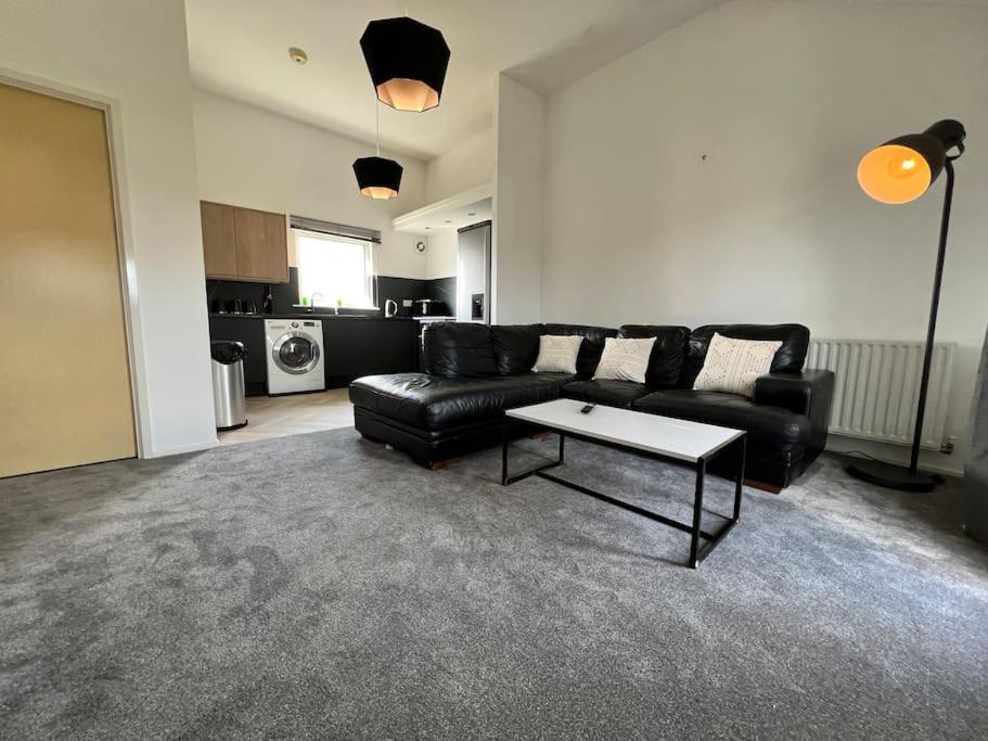 a living room with a black couch and a table at Luxury home in rugby ready 4U 