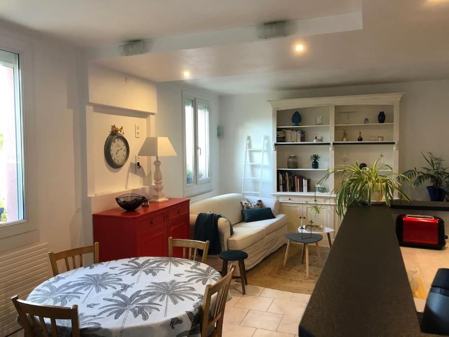 ein Wohnzimmer mit einem Sofa und einem Tisch in einem Zimmer in der Unterkunft Appartement en duplex avec parking et jardinet in Bourges