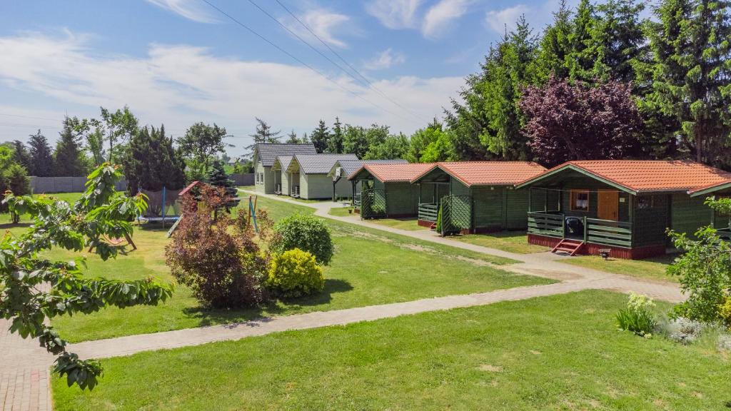 a row of green cabins in a park at Domek 7 osobowy piętrowy in Stegna