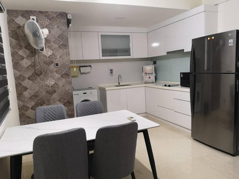 a kitchen with a table with chairs and a refrigerator at Summer Escapes in Johor Bahru
