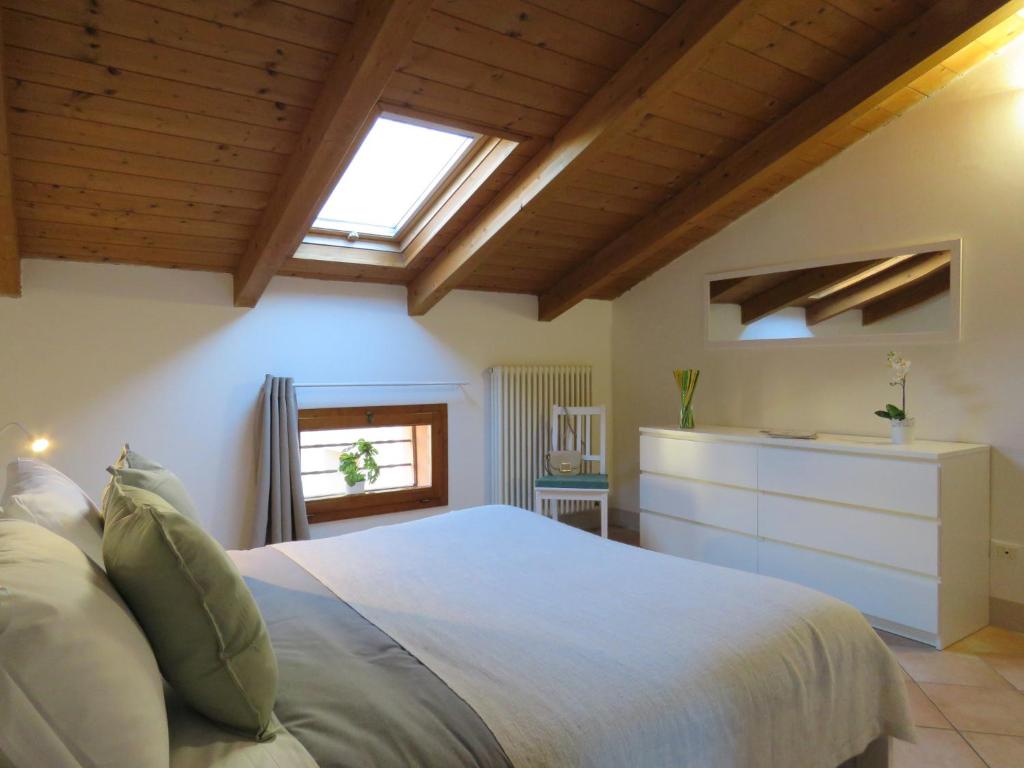 una camera da letto con un grande letto bianco e finestre di Campanile Apartment a Pieve di Cento